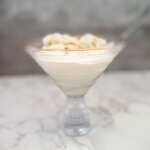 A cup of no churn orange ice cream with a spoon