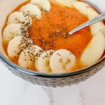 mango smoothie bowls topped with sliced bananas, apples, and chia seeds.