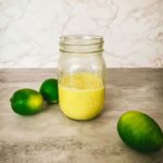 mason jar filled with lime curd and 3 limes